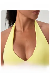 Détail de la brassière de yoga jaune à col licou avec décolleté en V profond et nœud torsadé