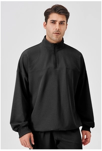 Close-up of black half-zip sweatshirt featuring waffle texture and standing collar detail