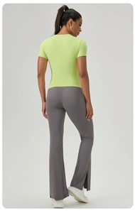 Détail d'un t-shirt de sport vert fluo moulant et d'un pantalon de yoga évasé gris