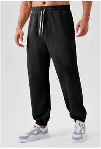 Detail view of men's black joggers featuring an adjustable drawstring and elastic waistband