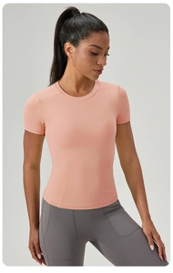 Détail d'un t-shirt de yoga ajusté rose-orange avec coutures princesse et col rond