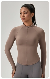 Detail eines hellbraunen Langarm-Yoga-Tops mit Halbreißverschluss, Daumenlöchern und Saum
