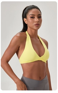 Détail de la brassière de yoga jaune à col licou noué avec legging de sport gris