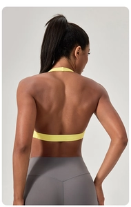 Vue détaillée du dos d'un soutien-gorge de sport jaune avec large bande de maintien