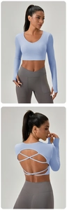 Détail du haut de yoga bleu clair avec dos croisé et leggings de sport gris clair