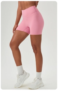 Detail of pink high-waisted yoga shorts showing elastic fabric and side contouring