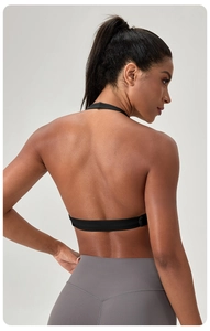 Gros plan d'une brassière de yoga dos nu noire et d'un legging gris sur un mannequin fitness