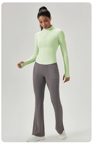 Detail eines lindgrünen Yoga-Oberteils mit Daumenlöchern und grauen ausgestellten Leggings
