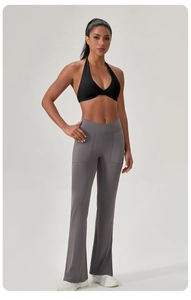 Détail de brassière de yoga noire et pantalon évasé gris avec taille en V et poches