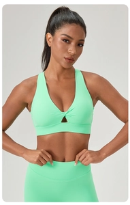 Close-up of mint green yoga bra featuring V-neck cross pleats and triangle cutout detail