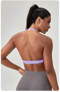 Détail de la brassière de yoga dos nu violette et du legging gris vus de profil