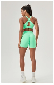 Rear view of neon green yoga set featuring criss-cross sports bra and scrunch butt shorts