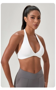 Détail du haut de yoga licou blanc noué et du legging gris à taille croisée en V