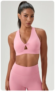 Detailed view of pink yoga bra with twisted cutout front and matching leggings set