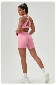 Detail view of pink yoga set showing criss-cross back sports bra and scrunch butt shorts