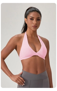 Détail d'un soutien-gorge de yoga dos nu rose clair avec col en V et ourlet croisé