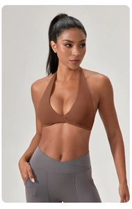 Détail de la brassière de sport marron à dos nu et du pantalon de yoga gris extensible