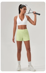 Nahaufnahme eines hochelastischen Sport-BHs mit V-Ausschnitt und lindgrüner Kurzhose