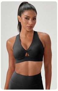 Detail of black cross-knot yoga bra with cutout design and supportive elastic fabric