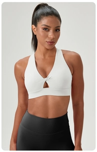 Detail of white yoga bra with twist front knot design and cutout V-neckline texture