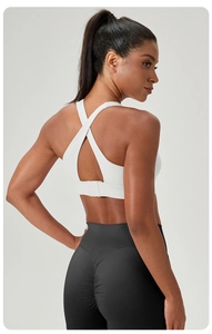 Detail view of white sports bra with back buckle and black high waist ruched yoga leggings