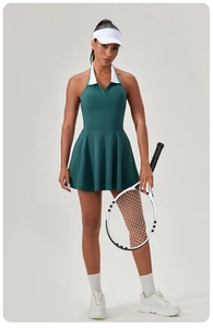 Close-up of dark green tennis dress featuring white lapel collar and pleated skirt detail
