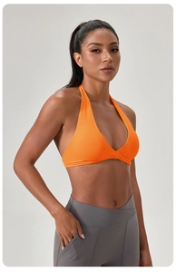 Gros plan d'un soutien-gorge de yoga orange vif avec plis croisés et legging taille en V