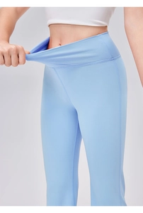 Detail der hochelastischen hellblauen High-Waist-Yoga-Schlaghose beim Dehnen des Stoffs