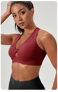 Detail of burgundy yoga bra with front twist hollow-out design and sweat-wicking fabric