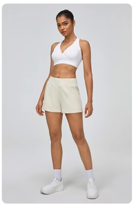 Détail du short de sport beige taille haute pour femme avec poches latérales et tissu fluide