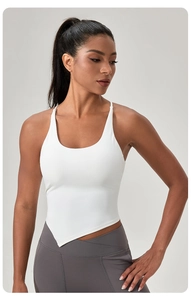 Dettaglio del top sportivo bianco con orlo asimmetrico e scollo a U per yoga e fitness