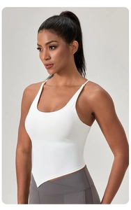 Dettaglio del top bianco da yoga con orlo asimmetrico e spalline sottili fitness