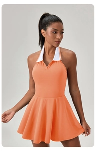 Detail of the orange halter-neck tennis dress with white polo collar and pleated A-line skirt