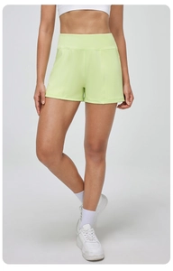 Détail du short de yoga vert clair à taille haute en tissu élastique et respirant