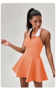Detail of orange halter tennis dress with white polo collar and pleated A-line skirt