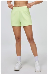 Détail du short de yoga vert clair à taille haute avec large ceinture et poches latérales