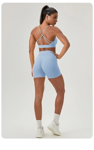 Détail ensemble de yoga bleu clair avec brassière à dos croisé et short froncé fessier