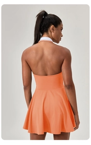 Back view of orange halter neck sports dress with a striped collar and flared hem
