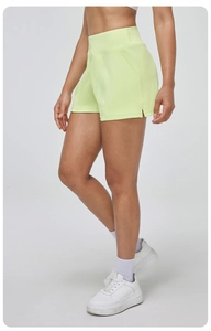 Détail du short de sport néon à taille haute avec fentes latérales et gaine abdominale