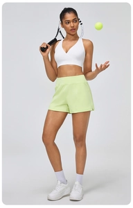 Détail du short de sport vert fluo taille haute et du soutien-gorge blanc col en V