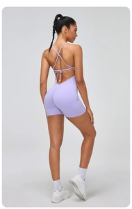 Detail view of light purple yoga romper with criss-cross back straps and ruched butt design