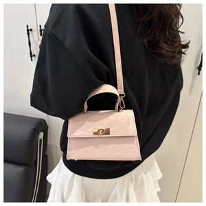 Detail of pink mini handbag with unique wrinkled texture and elegant golden twist lock