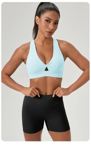 Front view of light blue yoga bra with twist hollow detail and black gym shorts
