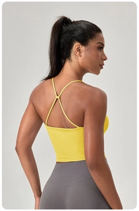 Vista dettagliata delle spalline incrociate sulla schiena di un crop top yoga giallo