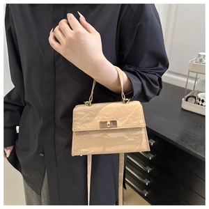 Detail of beige pleated shoulder bag with gold twist-lock and textured retro finish
