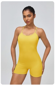 Front view of yellow one-piece yoga romper featuring thin straps and elastic knit fabric