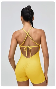 Detailed back view of yellow yoga bodysuit featuring cross straps and a tie-up bow design