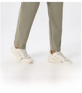 Detail shot of men's tapered athletic pants in olive green showing fit and ankle cuff