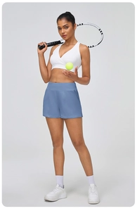 Détail du short de course bleu à taille haute avec poche latérale sur un modèle fitness