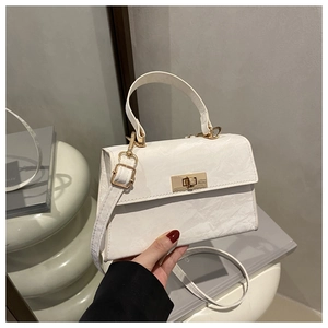 Close-up of marble texture on white crossbody bag with gold rotating lock buckle